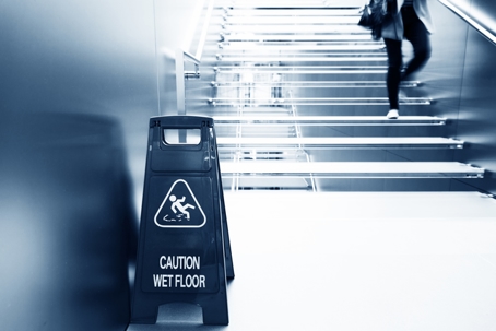 wet floor caution sign near the glass staircase.