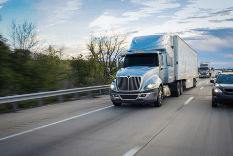 large truck speeding past another car on highway