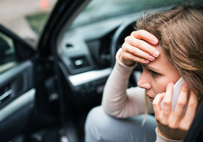 Woman on the phone after a car accident in Woodbridge