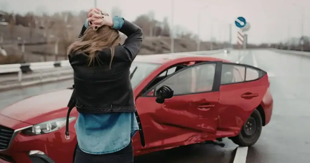 Stressed out lady looking at her car after a bad accident