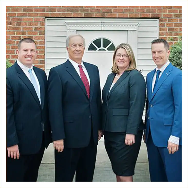 Palmisano & Goodman attorneys group outside a brick building, professional headshots in business su.